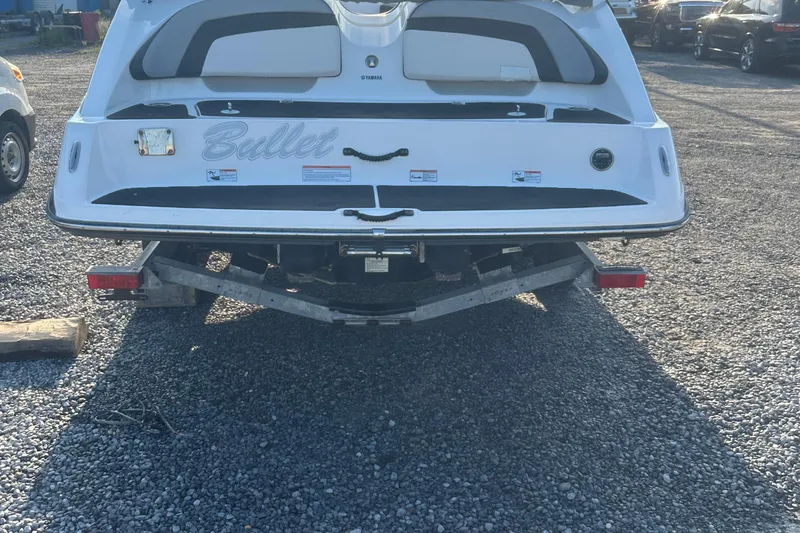 Slide: The Image of Rear view of a 2013 Yamaha Boats 212SS on a trailer, parked on gravel. - 19