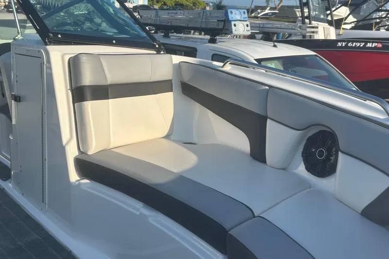 Slide: The Image of 2013 Yamaha Boats 212SS interior with cushioned seating and speaker, docked at marina. - 34