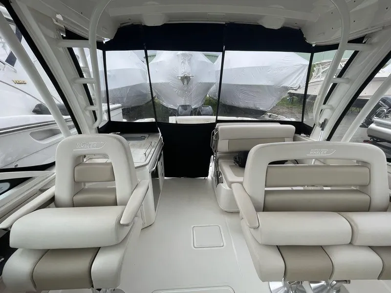 Slide: The Image of Interior of a 2016 Boston Whaler 320 Vantage boat with white seating and black canopy. - 14