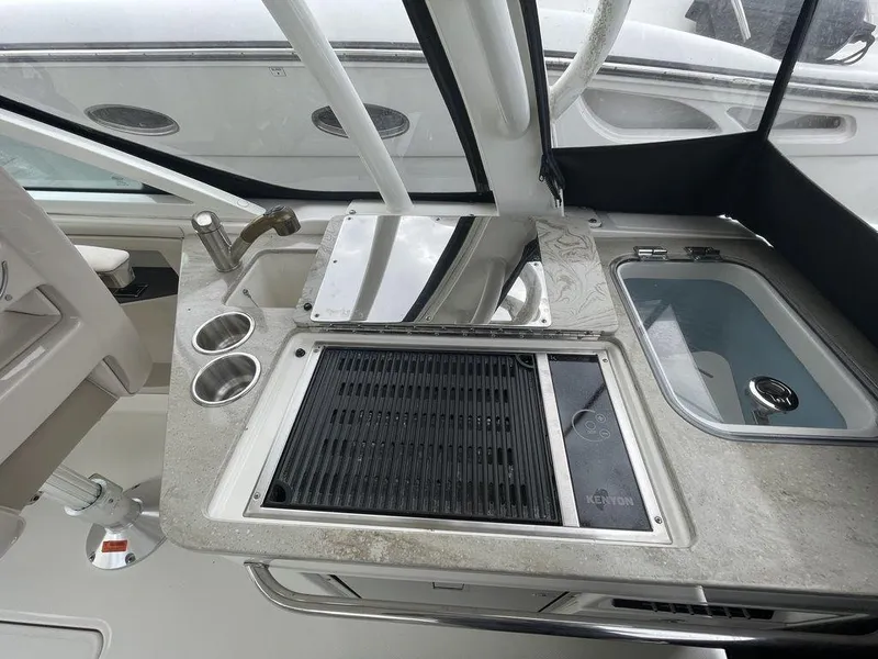 Slide: The Image of Boston Whaler 320 Vantage 2016 boat kitchen area with grill, sink, and storage. - 17