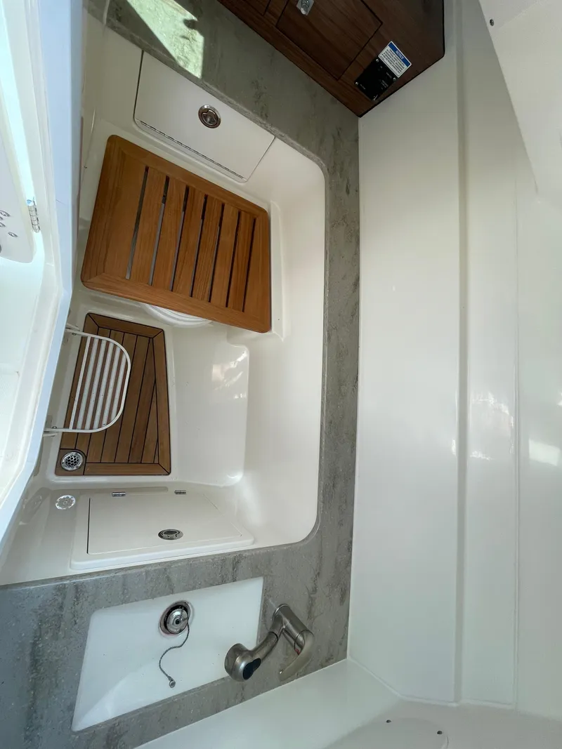 Slide: The Image of Interior view of 2016 Boston Whaler 320 Vantage boat with wooden seating and sink. - 25