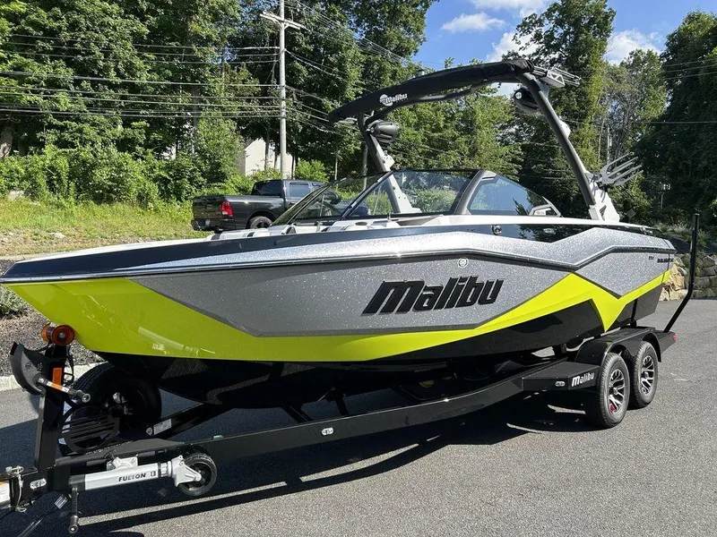 Slide: The Image of 2024 Malibu 22 LSV boat with vibrant yellow and gray design on a trailer. - 10