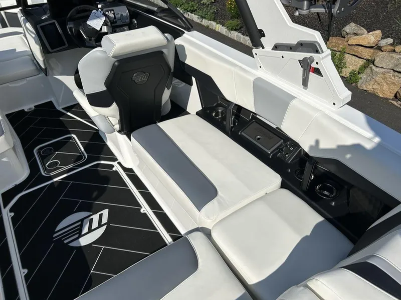 Slide: The Image of 2024 Malibu 22 LSV boat interior with white and black seating and flooring. - 11