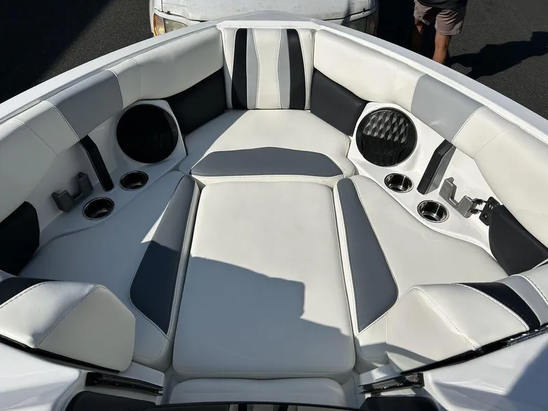 Slide: The Image of 2024 Malibu 22 LSV boat interior with white and black seating and cup holders. - 4