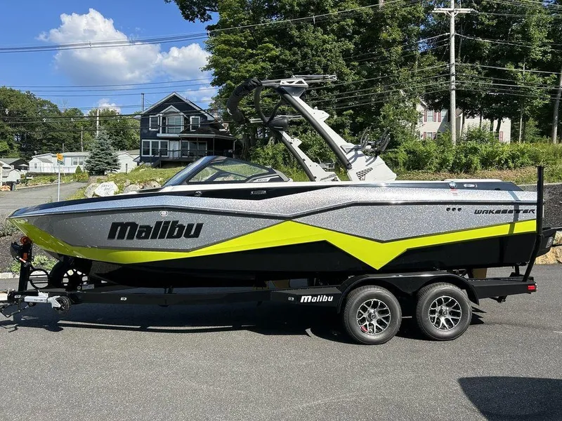 Slide: The Image of 2024 Malibu 22 LSV boat on trailer, parked outdoors on a sunny day. - 5