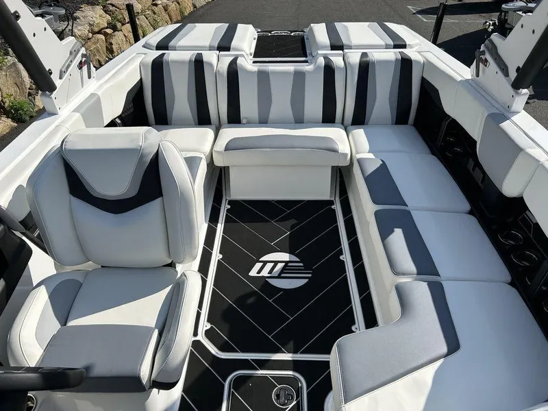 Slide: The Image of 2024 Malibu 22 LSV boat interior with white and gray seating and logo on floor. - 7