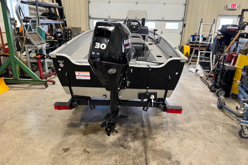 Slide: The Image of 2024 Lund 1600 Fury SS boat with Mercury 30 engine in a workshop setting. - 25