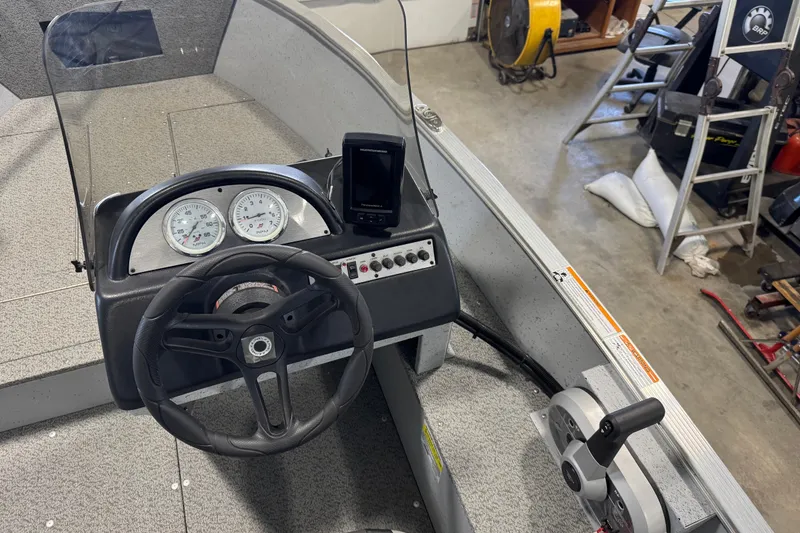 Slide: The Image of 2024 Lund 1600 Fury SS boat dashboard with steering wheel and control panel. - 27