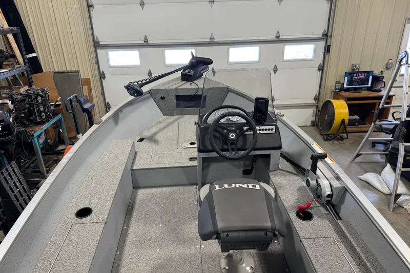 Slide: The Image of 2024 Lund 1600 Fury SS boat interior with steering console in a garage setting. - 29