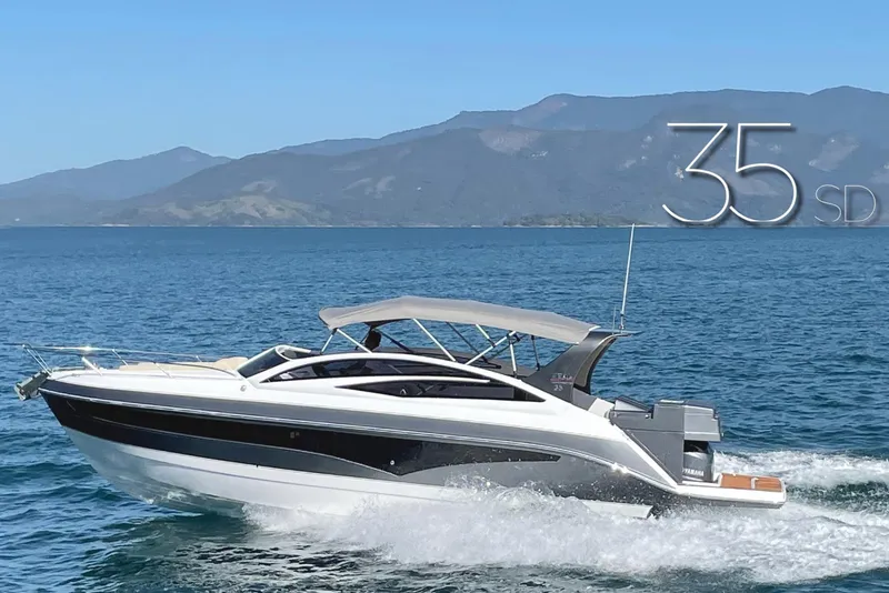 The Image of 2023 Real 35 Special Deck (SD) boat cruising on a scenic lake with mountains in the background. - 1