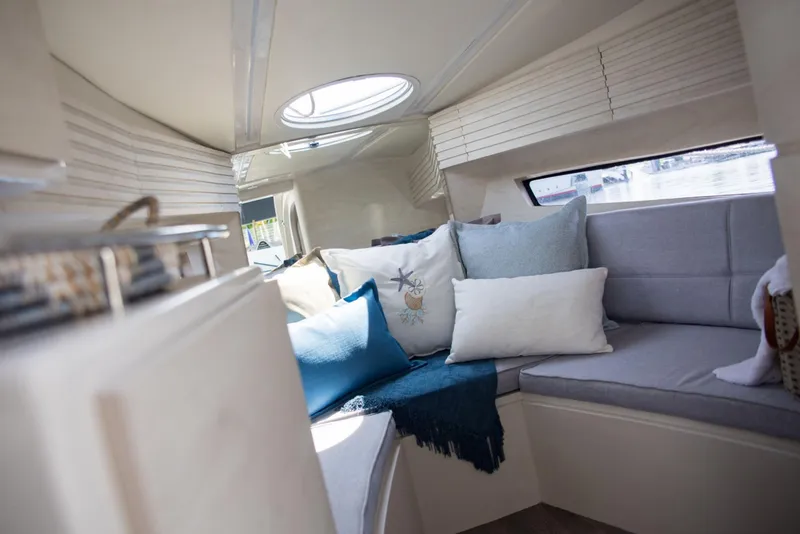 Slide: The Image of Cozy interior of 2023 Real 35 Special Deck (SD) boat with cushions and natural light. - 11