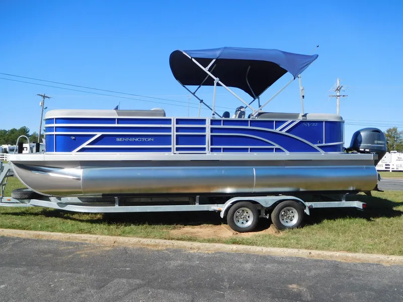 Slide: The Image of 2024 Bennington 22 SVSR pontoon boat with blue canopy on trailer. - 1