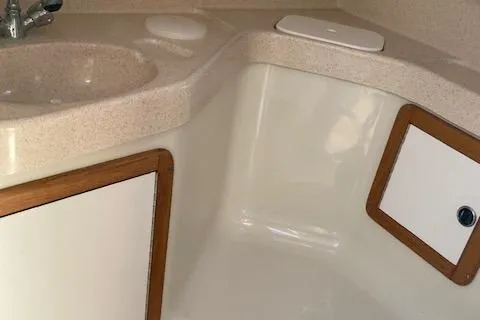 Slide: The Image of Interior of 2002 Catalina 34MK II sailboat, featuring a compact bathroom sink and storage. - 12