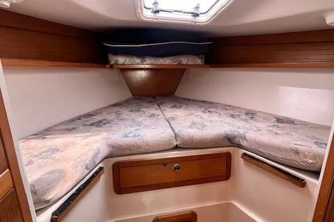 Slide: The Image of 2002 Catalina 34MK II sailboat cabin with V-berth and wooden storage. - 19