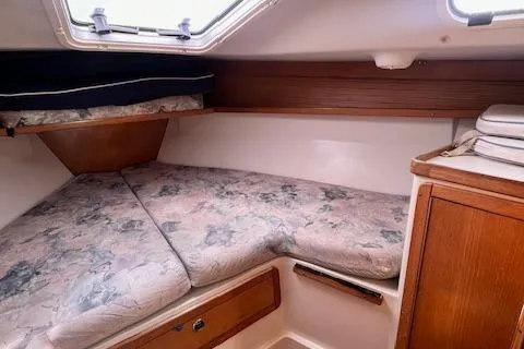 Slide: The Image of Cozy cabin interior of 2002 Catalina 34MK II sailboat with cushioned berth and wooden cabinetry. - 20