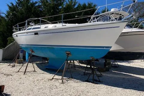 Slide: The Image of 2002 Catalina 34MK II sailboat on stands, white hull with blue bottom, outdoors. - 4