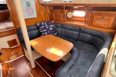 Slide: The Image of 2002 Catalina 34MK II yacht interior with cozy seating and wooden table. - 7