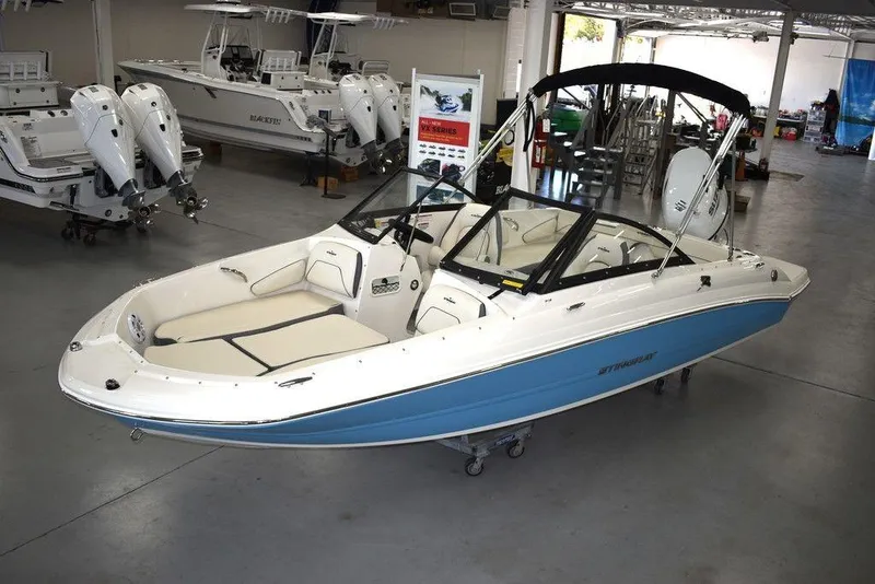 Slide: The Image of 2024 Stingray 191DC boat in showroom, blue and white exterior. - 1