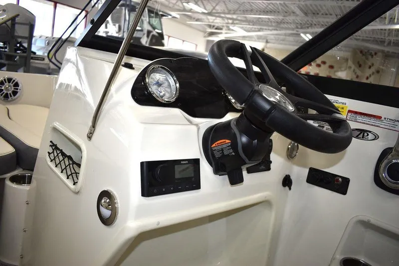 Slide: The Image of 2024 Stingray 191DC boat dashboard with steering wheel and control panel. - 11