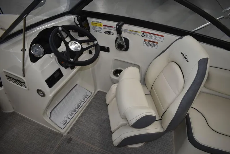 Slide: The Image of 2024 Stingray 191DC boat interior with steering wheel and captain's chair. - 15