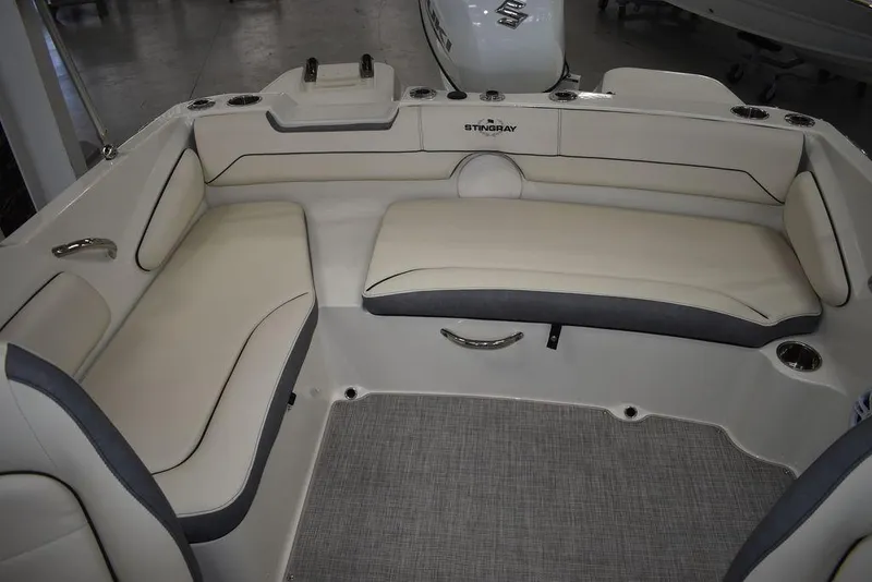 Slide: The Image of 2024 Stingray 191DC boat interior with beige seating and gray accents. - 18