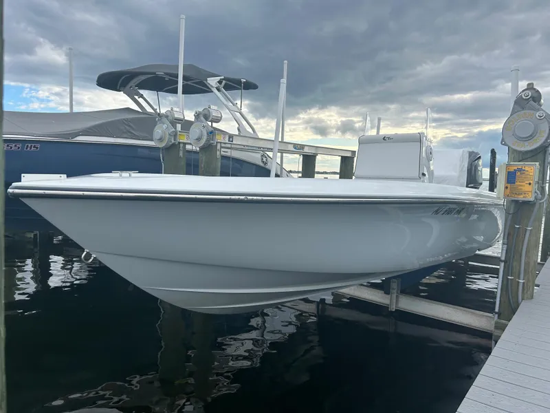 Slide: The Image of 2022 Contender 25 Bay boat docked at a marina under cloudy skies. - 14
