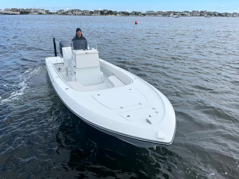 Slide: The Image of 2022 Contender 25 Bay boat cruising on a calm waterway. - 2
