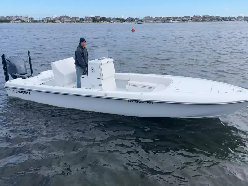 Slide: The Image of 2022 Contender 25 Bay boat on water with a person at the helm. - 6