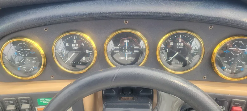 Slide: The Image of Dashboard of a 2001 Carver 396 Motor Yacht with gold-rimmed gauges. - 14