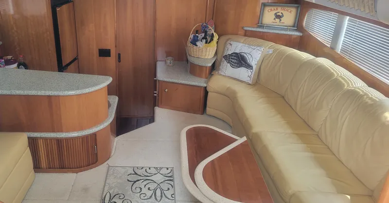 Slide: The Image of Interior of 2001 Carver 396 Motor Yacht with beige leather seating and wooden cabinetry. - 4