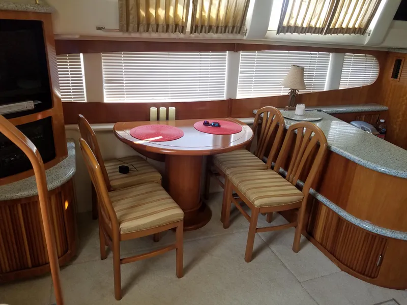Slide: The Image of Interior dining area of 2001 Carver 396 Motor Yacht with wooden table and chairs. - 5