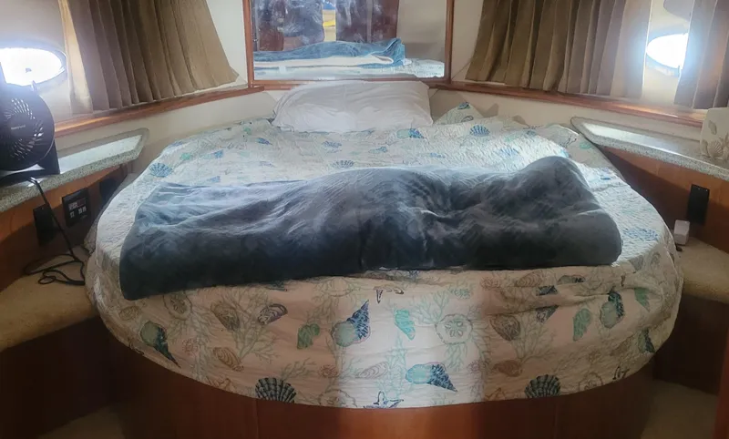 Slide: The Image of Cozy bedroom in a 2001 Carver 396 Motor Yacht with a round bed and nautical-themed bedding. - 9