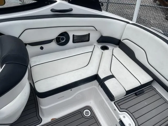 Slide: The Image of 2018 Yamaha Boats AR210 interior seating with white and black upholstery. - 15