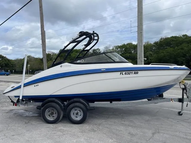 Slide: The Image of 2018 Yamaha Boats AR210 on trailer, white and blue, side view. - 4