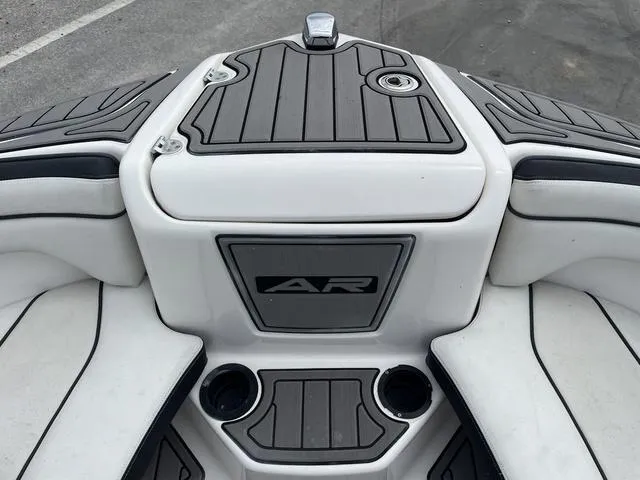 Slide: The Image of 2018 Yamaha Boats AR210 bow seating area with cup holders and storage. - 9