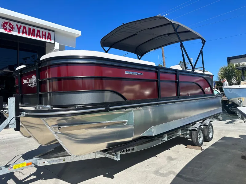 Slide: The Image of 2024 SunCatcher Select 322RC pontoon boat on a trailer outside a Yamaha dealership. - 1