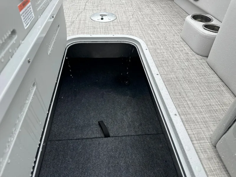 Slide: The Image of 2024 SunCatcher Select 322RC boat storage compartment with carpeted interior. - 18