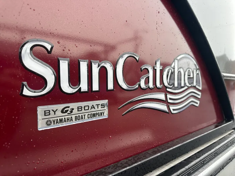 Slide: The Image of Close-up of 2024 SunCatcher Select 322RC boat logo on red surface. - 3