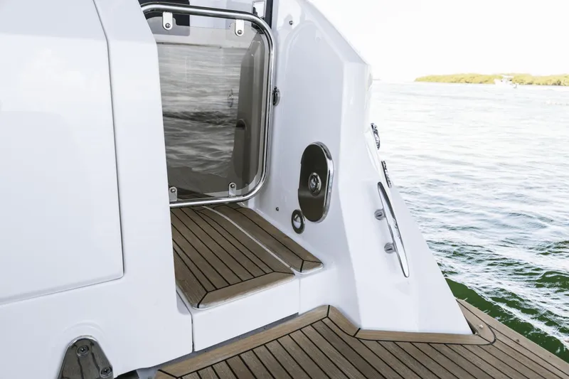Slide: The Image of 2024 Sea Ray Sundancer 320 Outboard boat deck with teak flooring and water view. - 17