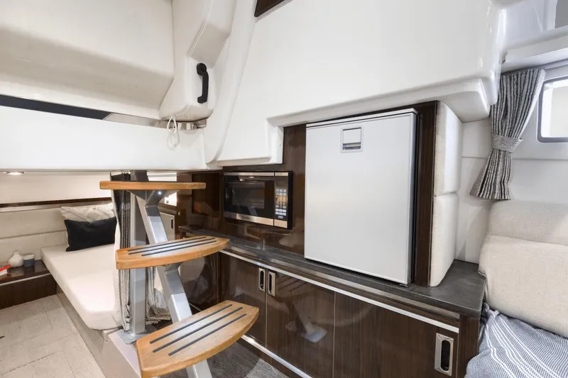 Slide: The Image of Interior of 2024 Sea Ray Sundancer 320 Outboard with modern kitchen and cozy seating area. - 7