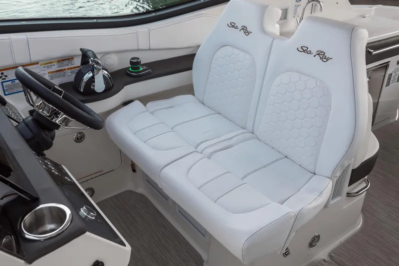 Slide: The Image of 2024 Sea Ray Sundancer 320 Outboard helm with dual white seats and steering wheel. - 9