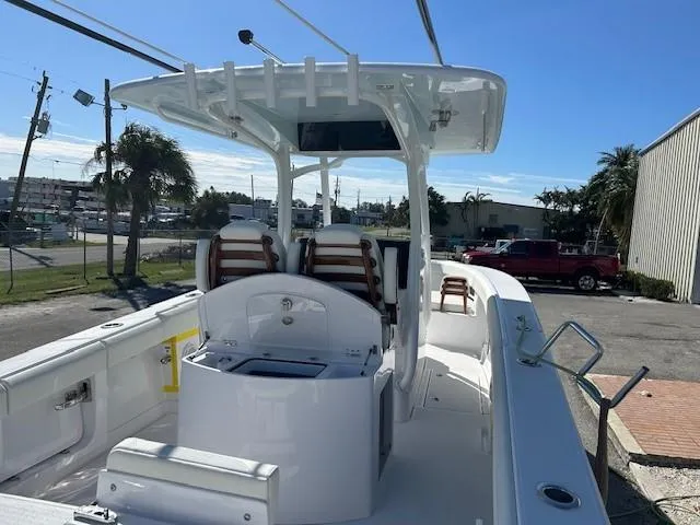 Slide: The Image of 2025 Jupiter 30 boat interior with seating and console, docked under clear sky. - 2
