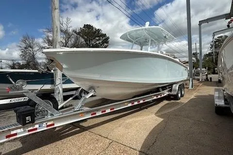 Slide: The Image of 2025 Jupiter 30 boat on trailer, parked outdoors under cloudy sky. - 5