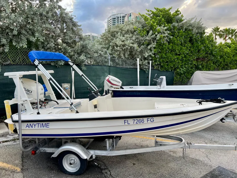 Slide: The Image of 1986 Hoog Comet 14 boat on trailer with blue canopy, labeled ANYTIME. - 5
