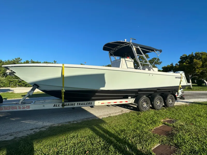 Slide: The Image of 2012 Contender 32 LS boat on All Marine Trailers trailer, parked on grass. - 1