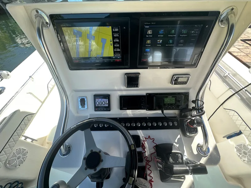 Slide: The Image of 2012 Contender 32 LS boat dashboard with dual navigation screens and steering wheel. - 15