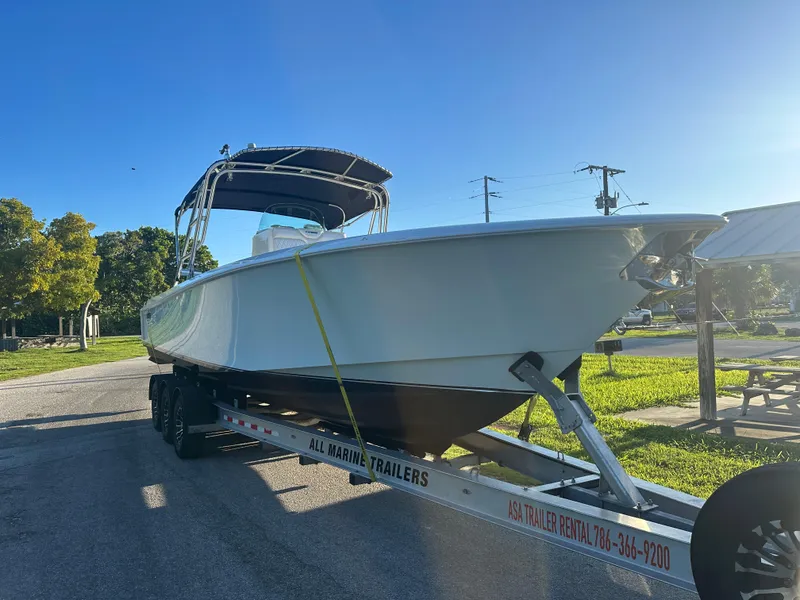 Slide: The Image of 2012 Contender 32 LS boat on a trailer in a sunny outdoor setting. - 2