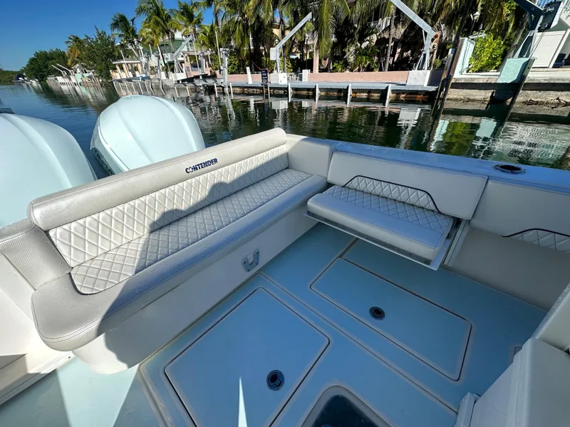 Slide: The Image of 2012 Contender 32 LS boat with cushioned seating and storage compartments. - 21
