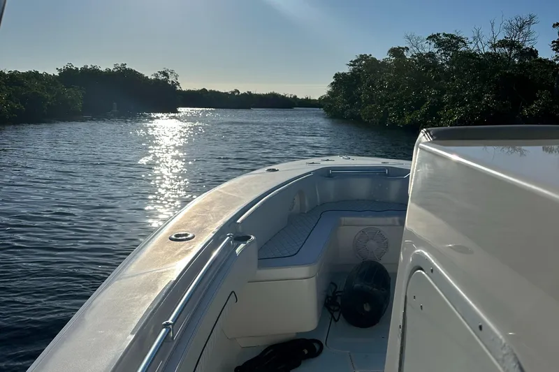 Slide: The Image of 2012 Contender 32 LS boat cruising on a serene waterway at sunset. - 22