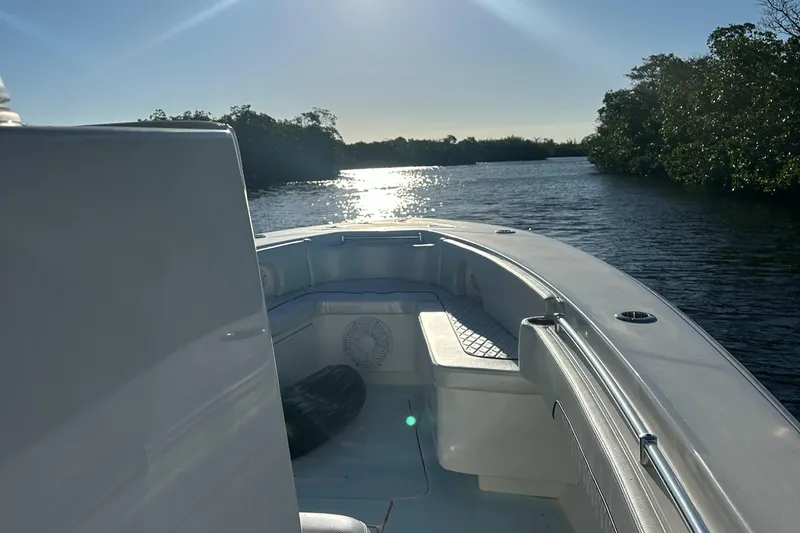 Slide: The Image of 2012 Contender 32 LS boat on a serene waterway at sunset. - 23